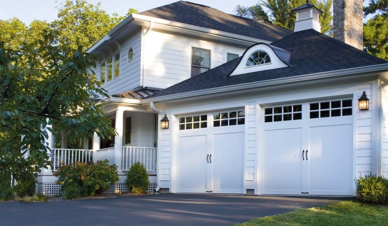 Coachman garage door on a white home with patio