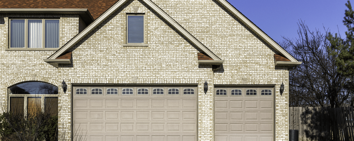 Three car wooden garage with driveway